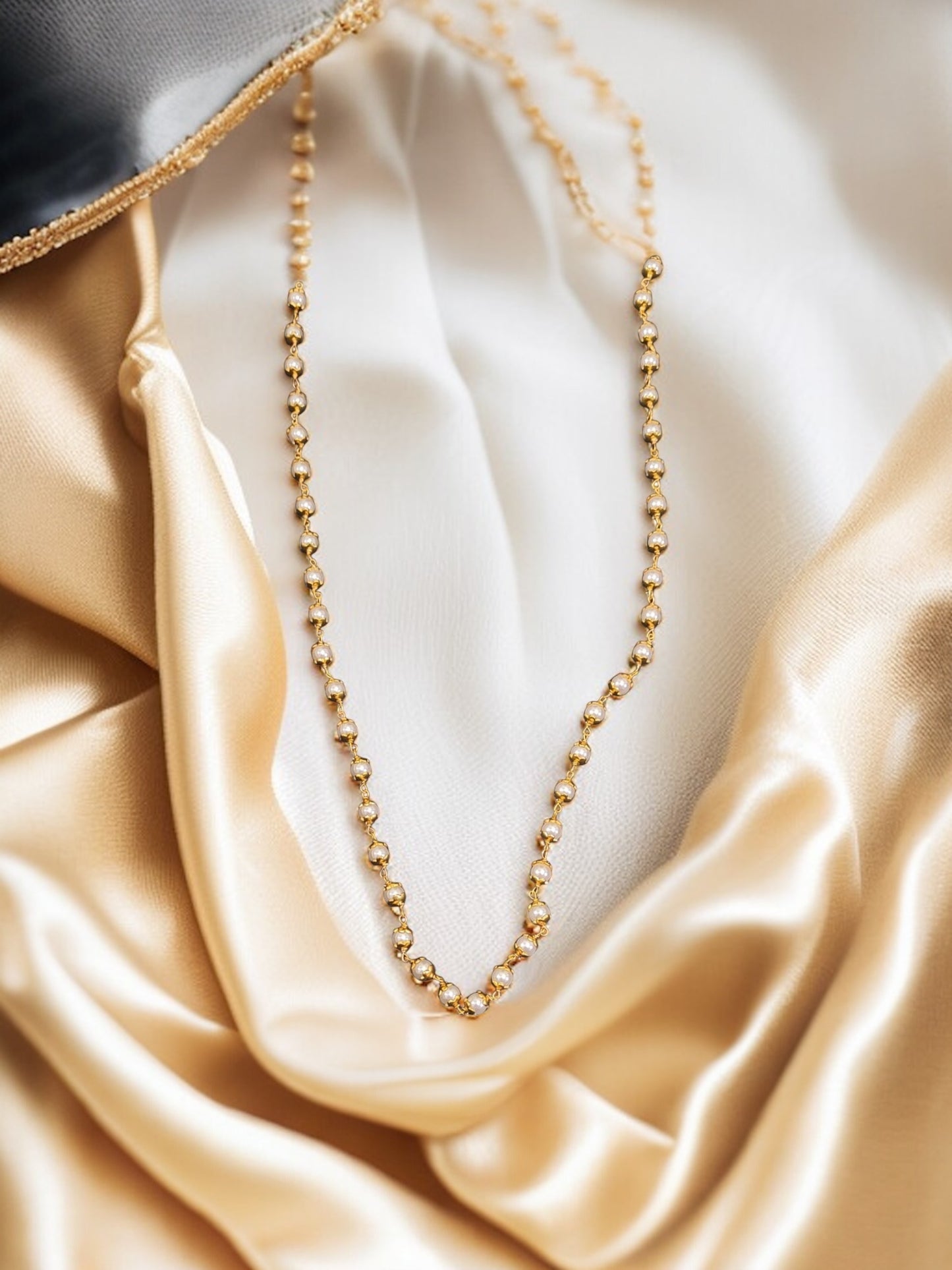 gold-plated chain with white stone beads.